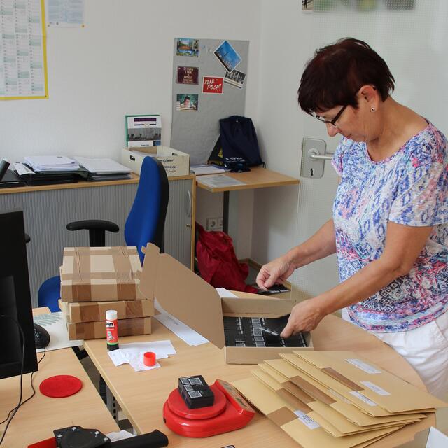 Petra Busche aus der RSB-Geschäftsstelle sortiert die LucaApp-Schlüsselanhänger für den Versand vor