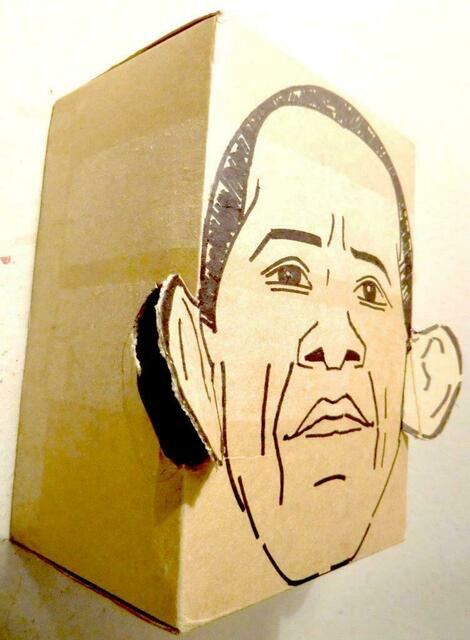 Obama, markanter Kopf aus gelbbraunem Karton, fast ein Superman-idol