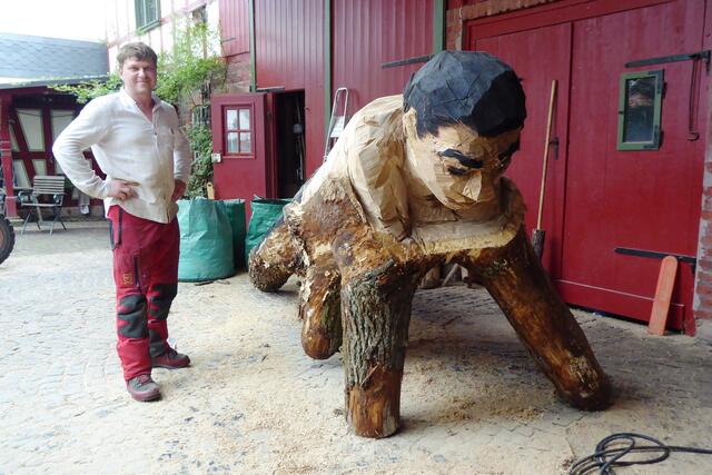 Und wie Edvardas Racevicius mit der Motorsäge am Stamm loslegte, kann man bei auf dem Stamm liegenden Mann erahnen. Zum Teil  ist die Bemalung schon aufgebracht. Spannend wird es sein, das fertige Kunstwerk am Kunstweg zu besuchen.