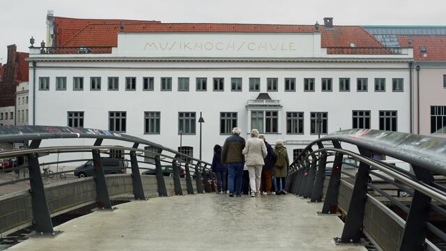 Besuchergruppe auf der Professorenbrücke in Richtung zur Musikhochschule. Foto: Helmut Kuzina