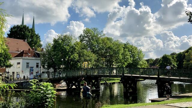 Die Dankwartsbrücke führt über die Trave zur Altstadtinsel, im Hintergrund sind knapp die Spitzen der Doppelturmanlage des Doms zu erkennen. Foto: Helmut Kuzina