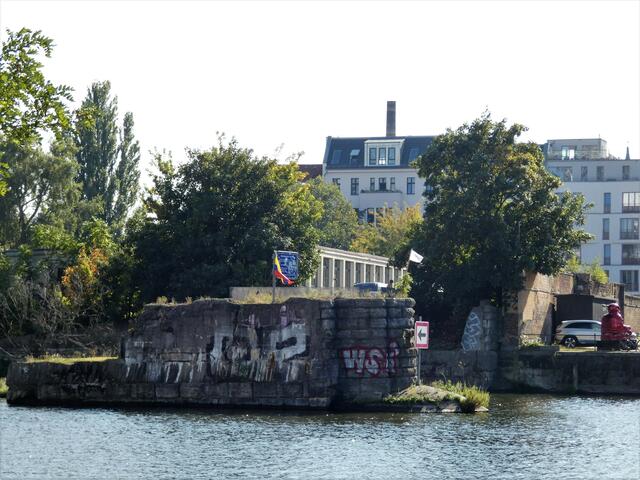 Nähe Spreebalkon auf der Kreuzberger Seite. Man sieht die Reste des letzten Pfeilers der ehemaligen Brommybrücke, die von 1909-1945 Friedrichshain mit Kreuzberg verband. Kurz vor Kriegsende wurde die Brücke gesprengt, um den Vormarsch der Roten Armee aufzuhalten.