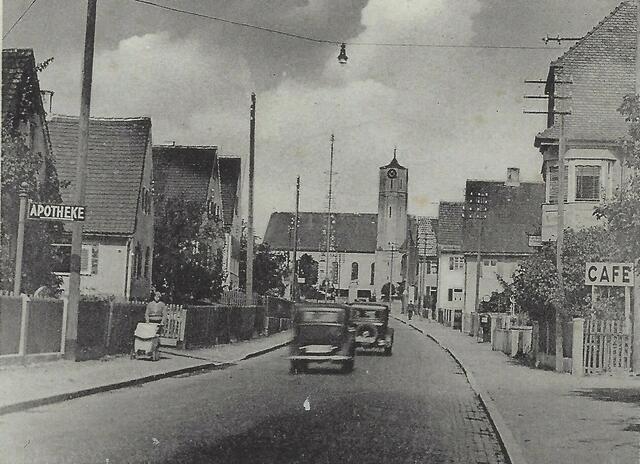 Im Jahr 1940 hat die Pfarrkirche den Umbau bereits hinter sich. Die Donauwörther Straße ist gepflastert. Rechts ist das “Cafe Dembinski“, später dann „Pizzeria Bel Mare“, „Kuhbar“ und heute „Pizzeria/Hotel Villa Toscana“.
Das Bild stammt von einer Ansichtskarte (ca. 1930)