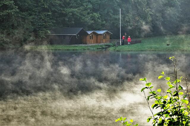 Osterteich: Über den Badeteich steigt aufgrund der kalten Luft (3°C) über dem noch etwa 12 °C warmen Osterteich am frühen Morgen Nebel empor. Gleichzeitig trifft die Morgensonne auf den Teich