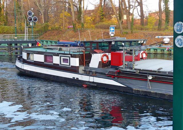 Schiff kommt aus der Schleuse. Im Hintergrund sieht man die Anlagen der Zitadelle Spandau.