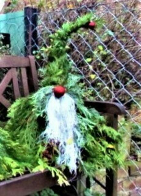 Lamettaartige Fäden mittig fassen, andahten und in Höhe der letzten Grünbindestelle einstecken. Diese Drahtstelle mit der Nase (Christbaumkugel, Wollknäul oder anders) verdecken