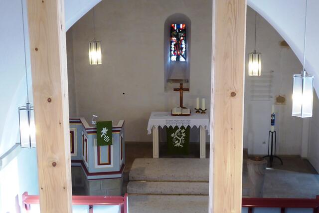 Blick von der Orgelempore durch die Deckenstützen zum Altarraum der evangelischen Kirche in Vöhl-Marienhagen.