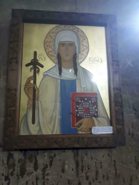Die Heilige Nino mit der Haarlocke am Kreuz.