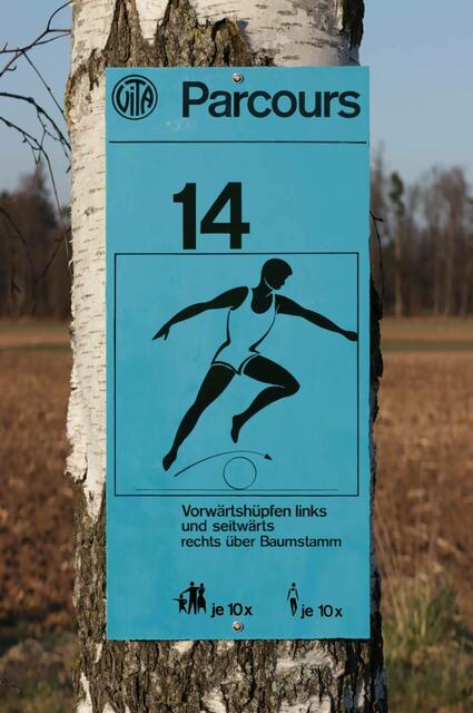 Ein rekonstruiertes Stationsschild veranschaulicht Unterschiede zur deutschen Variante: Keine abgerundeten Ecken, anderer Text und in diesem Falle eine Wiederholungsangabe, wobei der dargestellte Wert geraten ist