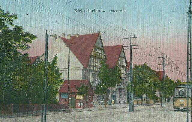 OKTOBER - Wir blicken um 1914 nordwärts in die SUTELSTRASSE. Der Himmel über dieser Straße ist so verdrahtet, dass die ehemaligen Telephonmasten aus Holz, die die Drähte der 22 Telephonbesitzer aus KLEIN-BUCHHOLZ im Jahr 1907 trugen, inzwischen durch eiserne Masten ausgetauscht wurden. 1913 baute der Kolonialwarenhändler HEINRICH SCHOHAUS an der SUTELSTRASSE 70, gegenüber des Straßenbahn-Depots eines der schönsten Häuser in KLEIN-BUCHHOLZ. Es ist ein mehrstöckiges Doppelgiebelhaus in Fachwerkoptik.
