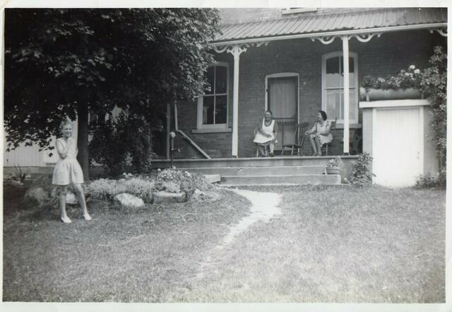 Henrys Frau Caroline und eine Nachbarin auf der Veranda, im Vordergrund die Enkelin.