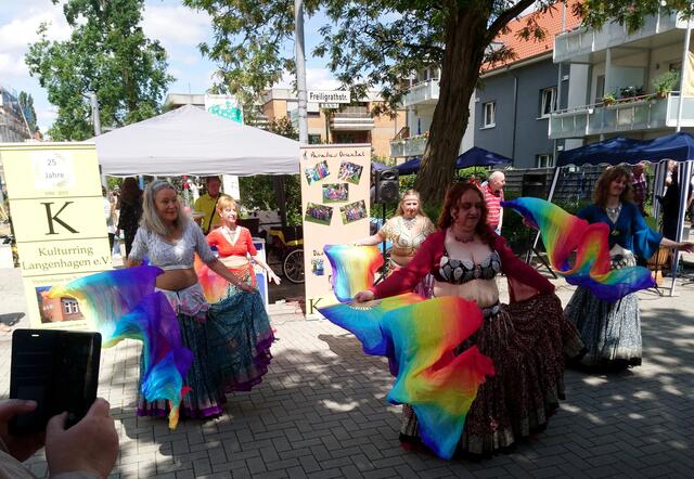 Hinter den Tänzerinnen ist der Stand des Kulturrings Langenhagen mit dem Vorsitzenden Jürgen Miethe zu sehen.