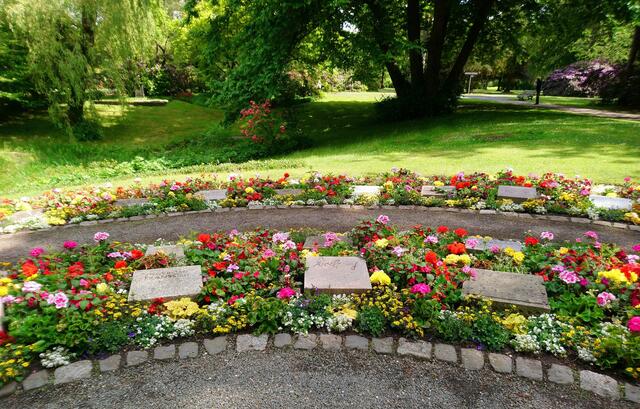 Die Grabstellen sind in bunte Blumenbeete eingebettet.