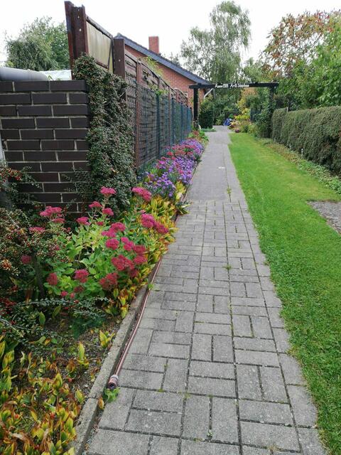 Rechts auf voller Länge mit Gittersteinen befestigt und mit Rasen durchwachsen.