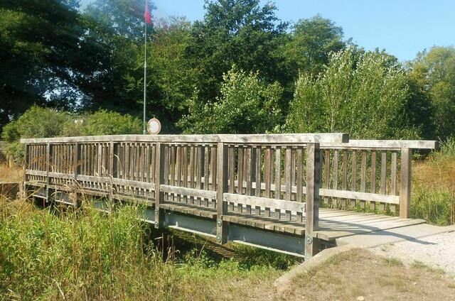 Brücke Fuhrbleek, kein Wasser mehr zu sehen. Die Fahne (oberer Bildrand) dokumentiert, dass eine Bundeswehr-Übung auf dem im Hintergrund von Bäumen verdeckten Truppenübungsplatz stattfindet.