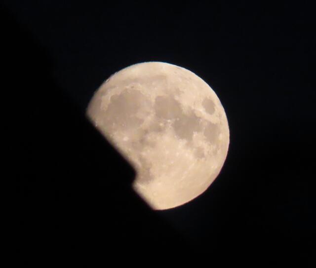 Der Mond kommt am 10.08.2022 gegen 21.30 Uhr hinter dem Dach vom gegenüberliegenden Haus hervor (das Foto habe ich mit 3/4 ausgefahrenem Zoom und ohne Stativ gemacht).