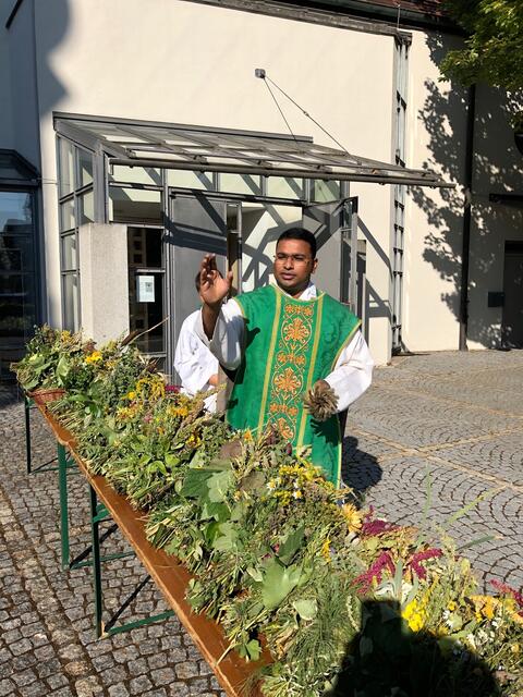 Pfarrer Abin segnet die Krautbuschen, die nach dem Gottesdienst gegen eine freiwillige Spende mit nach Hause genommen werden konnten.