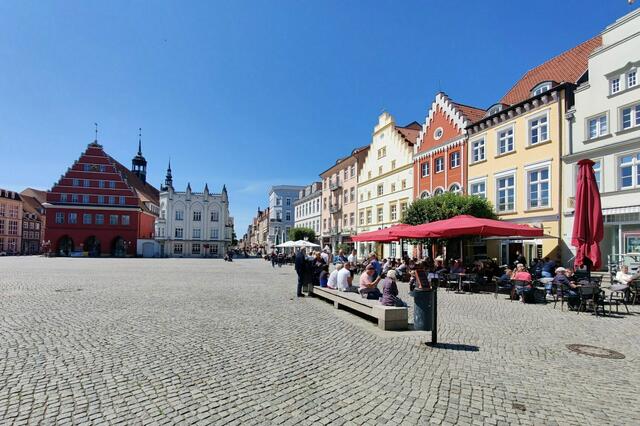 Der Greifswalder Marktplatz mit dem barocken Rathaus (rotes Gebäude hinten)