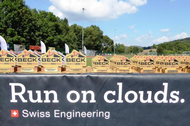 Vor der Siegerehrung des 1. HochRhön-BergTrails stehen die Siegertrophäen gut aufgereiht nach Plätzen und Altersklassen.