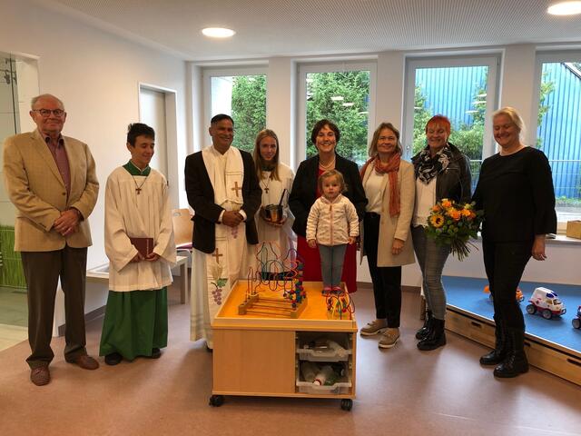 Sie alle freuen sich und strahlen nach der Segnung der Kinderkrippe v.l.n.r.: Oberingenieur i.R. Martin Oefele, Ministrant Andreas, Pfarrer Norman D´Souza, der Leiter der Pfarreiengemeinschaft Nordendorf-Westendorf, Ministrantin Tanja, Bürgermeisterin Christine Gumpp, Kindergartenleiterin Daniela Leser, stellvertretende Kindergartenleiterin Monika Zollondz, Architektin Susanne Oefele und eine kleine Besucherin aus der Kinderkrippe.