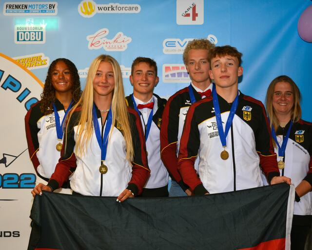 Phoenix Baumgardt, Leni Bauer und Carlo Müller (v.l.n.r.) gewinnen zusammen mit Nils Quigley (fehlt auf dem Bild) und ihren Teamkollegen Team-Bronze. Auch Nicole Hillenbrand (rechts) freut sich als Team-Captain über die Erfolge.