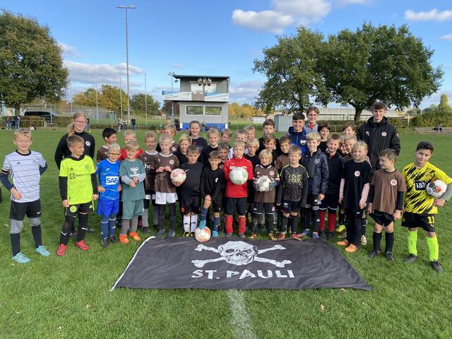 Ein gemeinsames Gruppenfoto mit den Trainern/in (v.l.) Maren, Jona und Len von der FC. St. Pauli-Fußballschule.
