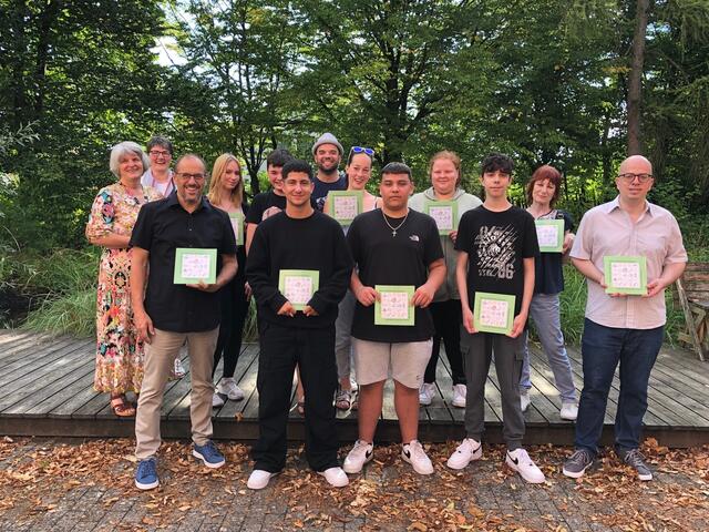 Sie freuen sich über ihr "Kochbuch der Freundschaft": Fachoberlehrerin Maria Christi (links), Andrea Gärtner (hinten links) vom Partnerschaftskomitee, Lehrer Florian Möckl (mit Hut), Marie Carbonell und Martin Stäbe (Zweite von rechts) und ganz rechts vom Partnerschaftskomitee mit den Schülerinnen und Schülern der M9-Klassen. Besonders stolz ist Rektor Peter Reithmeir (vorne links) auf seine Schüler und Lehrkräfte.
