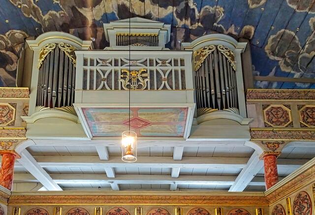 Orgelprospekt mit freistehendem Orgel-Spieltisch und Wolkenhimmel
