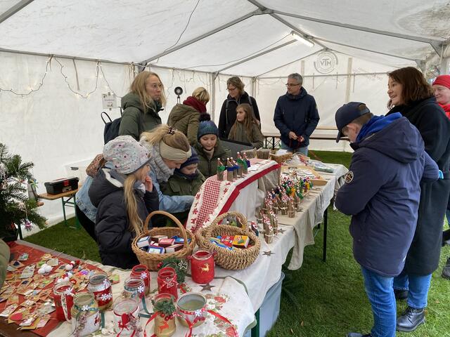Kinder der Grundschule Engelbostel verkaufen selbst gestaltete Ansichtskarten, Anhänger für den Weihnachtsbaum, kleine gebastelte Weihnachtsmänner und mehr.