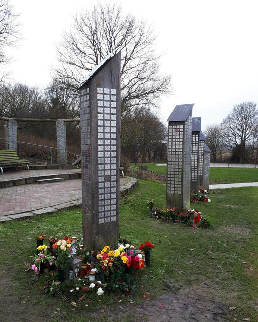"Erinnerungsstätte Seefrieden" - Holzstehlen mit Messingschilder für die Seebestatteten. Angehörige bringen Blumen im Gedenken an ihre Lieben.