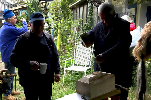 MdL.a.D. Max Strehle darf beim Gruselmaskenschnitzen beim Gablinger Percht Anton Rager selbst mal ausprobieren.