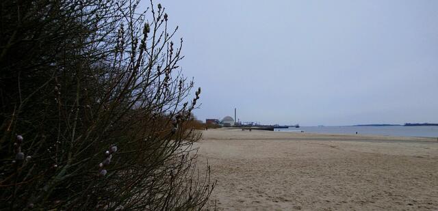 An der Elbe gibt es einige breite Sandstrände. Im Hintergrund ist das inzwischen aufgegebene Kernkraftwerk Stade zu sehen.