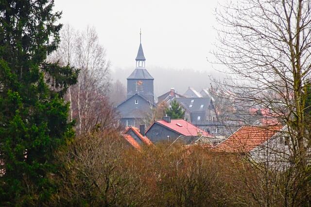 Blick auf den im Dunst liegenden Ort Benneckenstein mit der St. Laurentius Kirche