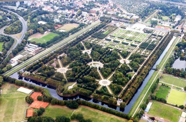 Dieser ist eine einzigartige Barockanlage. Sie misst etwa 800 mal 400 Meter im Rechteck. Rechts oben die kleine helle Fläche am Gartenende ist das Schloss. Dahinter beginnt der Berggarten, ein botanischer Garten. Die Wasserfläche rechts am Bildrand gehört zum Georgengarten, einem Englischen Garten. Durch ihn führt eine zwei Kilometer lange Lindenallee. Komplettiert werden die Gärten durch den Welfengarten mit der Uni, die einmal ein Schommer-Schloss der Welfen werden sollte.
