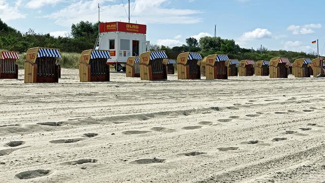 Die Strandkörbe stehen auf dem Sandstreifen zwischen der Düne und der Ostsee.