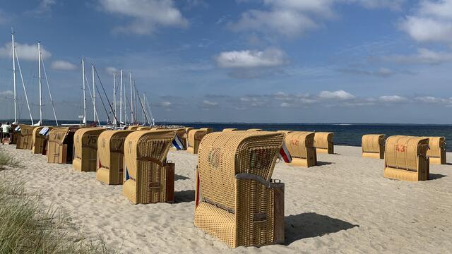 Es ist sehr früh am Strand von Timmendorf. Noch stehen fast alle Strandkörbe Reihe für Reihe wie an einer Schnur ausgerichtet auf dem feinen Sandstrand.