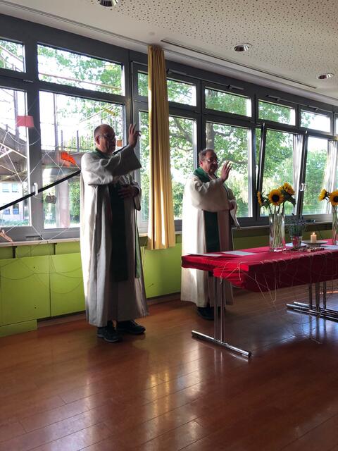 Foto: Diakon Dieter Frembs (links) und Pfarrer Gerhard Krammer segnen nach der ökumenischen Andacht die Mitfeiernden. 