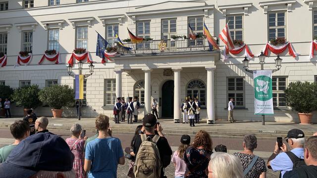 Viele Schaulustige versammeln sich vor dem Rathausportal. Foto: Helmut Kuzina