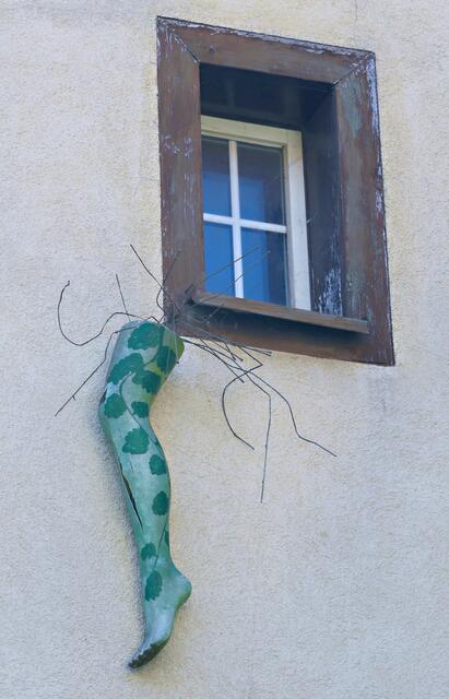 Gleich daneben hängt dieses umrankte Damenbein an der Fassade