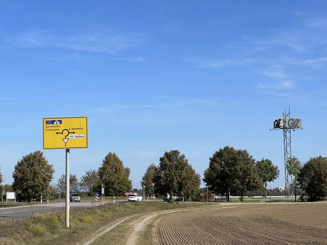 Einmündung von Neusäß kommend in den Kreisverkehr an der  Autobahnanschlussstelle Neusäß, Blick nach Norden, die Fläche für das geplante Gewerbegebiet liegt hinter dem Kreisverkehr, Oktober 2023