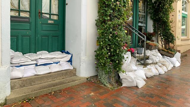 Anwohner und Geschäftsleute haben ihre Gebäude gegen das Hochwasser durch Sandsäcke gesichert. Foto: Helmut Kuzina