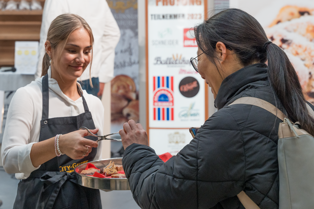 Stollenprüfung 2023 in der City-Galerie Augsburg - Gina Huber (links) von der City-Galerie Augsburg verteilt "Probiererle" die Galerie-Besucher | Foto: FSeventfoto
