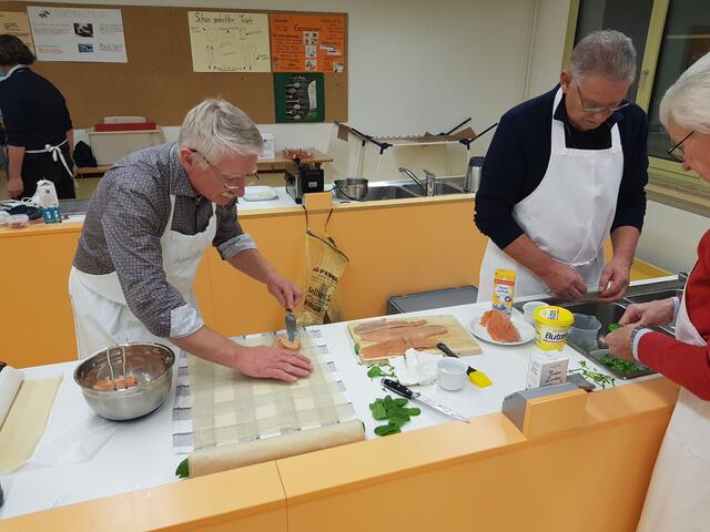 Willi Buhmaier und Hans Miller (ganz rechts) befreien den Babayspinat von den Stielen. Die erste Forellenroulade ist schon fertig.