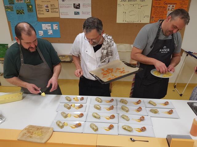 Als Arzt ist man ja den Umgang mit der Pinzette gewohnt. Hier setzt sie Alois Moosmiller (Mitte) aber zur Dekoration des Desserts mit Kumquats ein. Johannes Steichele (links) macht Pyramiden aus Orangenmouse und Nocken aus Schokoladenmous, während Stefan Kaiser sich noch überlegt, ob er die gemahlenen Pistazien noch dazu streut.