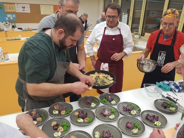Ganz rechts Klaus Hill, der für den gelungenen Kochabend die Oberhand hatte. Sobald überall die zweite Jakobsmuschel auf dem Teller liegt wird sofort aufgetragen.