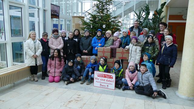 Die Klasse 4b mit Ihrer Lehrkraft Frau Sonja Killewald und den Mitarbeitern der Johanniter Herr Andre Bender und Frau Prestel halfen freudig beim Beladen des Päckchen.