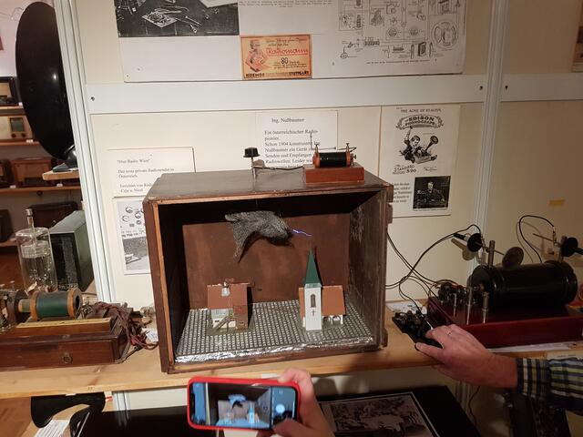 Hier hat hans Walchofer das Experiment der Funkeübertragung sichtbar in ein altes Radiogehäuse eingebaut. Den Kontakt zum Funkendetecktor stellt er mit einer alten Morsetaste her. Bei genauer Betrachtung sieht man den Funkenschlag.