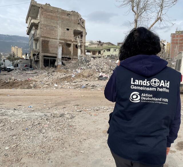 LandsAid-Einsatzkraft Sylvia Rohrhirsch vor zerstörtem Gebäude  | Foto: LandsAid e. V. 