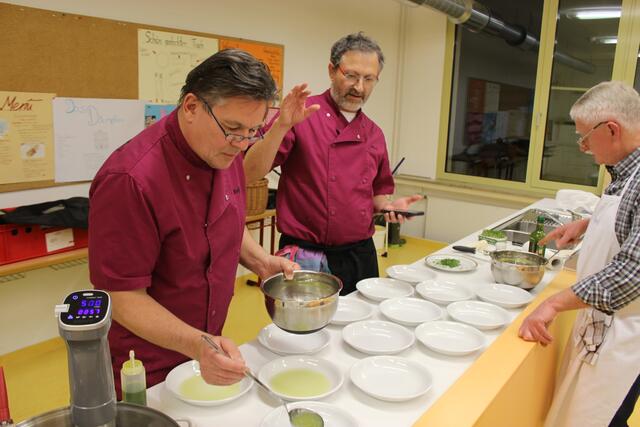 Ralph Hausbalk (links) füllt den Apfel-Sellerie-Sud für den ersten Gang in die Teller. Dr. Alois Moosmüller (Mitte) und Georg Lipp besprechen wie es weitergeht. 