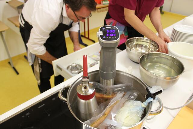 In diesem Topf gart der vakuumierte Lachs, das Selleriepüree wird warmgehalten. Man sieht der Sousvide-Stick ist auf 50 Grad gestellt, die Zeit zeigt an, dass man in cirka 11 Minuten anrichten kann. Mit dem Syphon wird das Selleriepüree auf den Teller gespritzt.